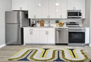 Orange apartment for rent - A modern kitchen with white cabinets and stainless steel appliances.