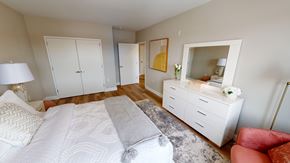 Newark apartment for rent - A bedroom with a large bed and a red chair.
