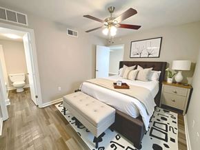 Shreveport apartment for rent - A bedroom with a large bed and a ceiling fan.