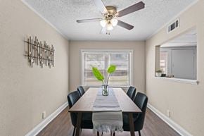 Shreveport apartment for rent - A dining room with a table, chairs, and a ceiling fan.