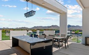 Scottsdale apartment for rent - A modern outdoor kitchen with a hot tub and a view of the mountains.