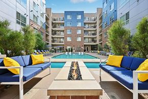 Denver apartment for rent - A pool surrounded by blue couches and yellow pillows.