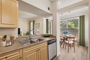 Cincinnati apartment for rent - A kitchen with wooden cabinets and a dining table.