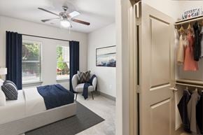 Charlotte apartment for rent - A bedroom with a bed, chair, and a wardrobe.