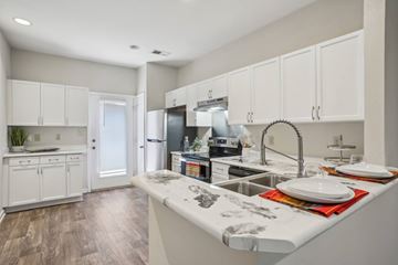 Charlotte apartment for rent - A kitchen with white cabinets and a wooden floor.