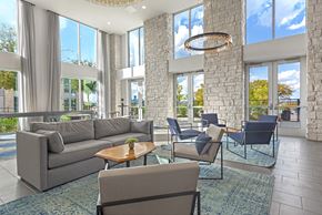 Austin apartment for rent - A living room with a grey couch, a coffee table, and a chandelier.