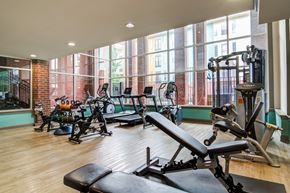 Atlanta apartment for rent - A gym with a row of exercise bikes and a row of weight machines.