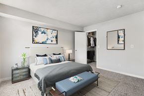 Cincinnati apartment for rent - A bedroom with a bed, nightstand, and a painting on the wall.
