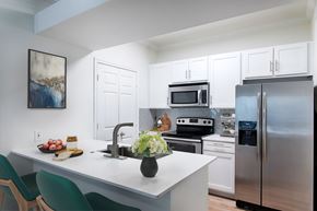 Frisco apartment for rent - A kitchen with a white counter and green chairs.