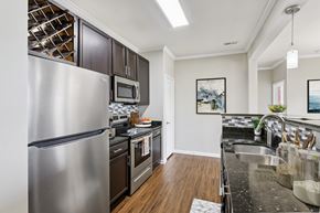 Zionsville apartment for rent - A modern kitchen with a stainless steel refrigerator and black cabinets.