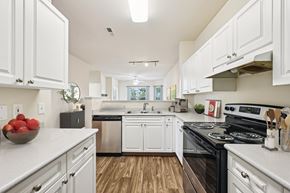 Columbus apartment for rent - A modern kitchen with white cabinets and a black stove top oven.