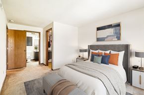 Moraine apartment for rent - A bedroom with a large bed and a painting on the wall.