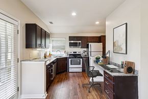 Miamisburg apartment for rent - A kitchen with dark brown cabinets and white appliances.