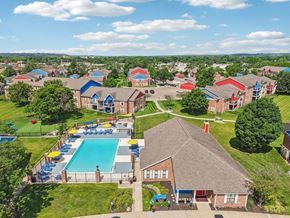 Moraine apartment for rent - A large swimming pool surrounded by a fence and a grassy area.