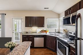 Miamisburg apartment for rent - A kitchen with dark wood cabinets and stainless steel appliances.