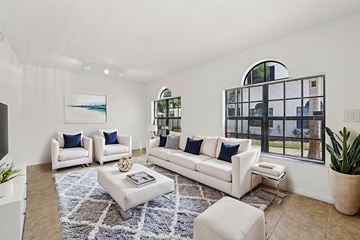 Miramar apartment for rent - A living room with white furniture and a large window.