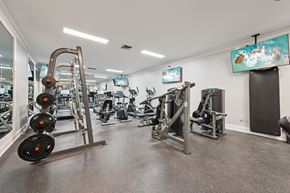 Columbus apartment for rent - A gym with a variety of equipment including a weight bench, a leg press machine, and a treadmill.