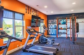 Blue Ash apartment for rent - A gym with orange walls and a sign that says "Get fit, don't quit".