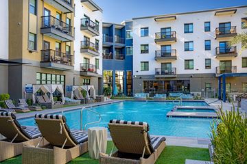 Scottsdale apartment for rent - A pool area with lounge chairs and a small boat in the water.