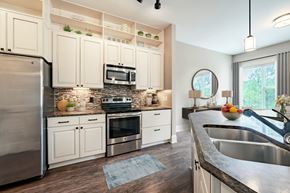 Cary apartment for rent - A modern kitchen with a stainless steel refrigerator and a microwave above the stove.