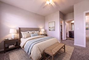 Carmel apartment for rent - A bedroom with a large bed and a bench.
