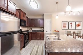 Woodbury apartment for rent - A kitchen with brown cabinets and a stainless steel refrigerator.