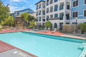 San Antonio apartment for rent - A swimming pool surrounded by a red brick border and a wooden fence.