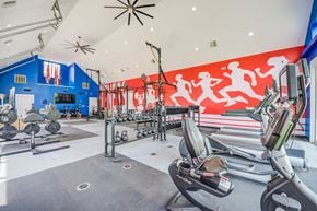 Columbus apartment for rent - A gym with a row of treadmills and a row of weight machines.