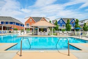 Columbus apartment for rent - A pool with a diving board and a building in the background.