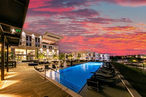Austin apartment for rent - A pool area with a sunset sky in the background.
