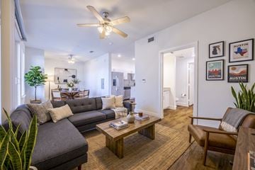 Austin apartment for rent - A living room with a grey couch and a brown leather chair.