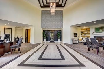 Charlotte apartment for rent - A spacious living room with a large rug and a chandelier.