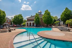 Columbus apartment for rent - A large swimming pool with a diving board and a building in the background.