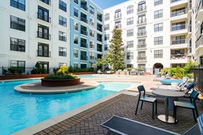 Atlanta apartment for rent - A pool surrounded by a patio with chairs and a table.