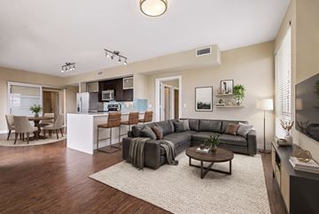 Denver apartment for rent - A modern living room with a grey sofa set and a wooden coffee table.