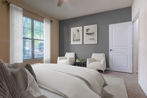 Charlotte apartment for rent - A bedroom with a large bed and two chairs.