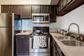 Miamisburg apartment for rent - A kitchen with a stove top oven and a refrigerator.
