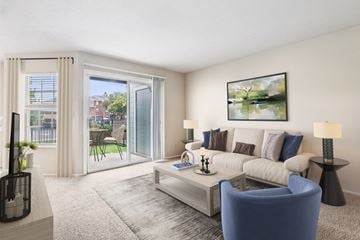 Miamisburg apartment for rent - A living room with a blue armchair, a white sofa, and a painting on the wall.