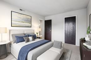 Miamisburg apartment for rent - A bedroom with a large bed and a painting on the wall.