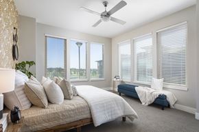 Denver apartment for rent - A bedroom with a large bed and a blue bench.