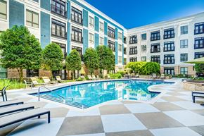 Durham apartment for rent - A large swimming pool surrounded by a tiled floor and lounge chairs.