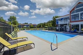 Cincinnati apartment for rent - A swimming pool with yellow sun loungers and a building in the background.