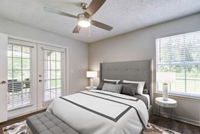 Tampa apartment for rent - A bedroom with a large bed and a ceiling fan.