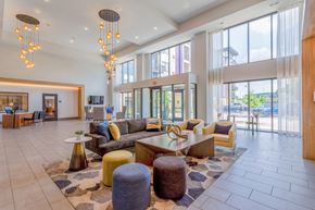 Burnsville apartment for rent - A large, open living room with a variety of seating options and a chandelier hanging from the ceiling.