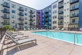 Burnsville apartment for rent - A pool surrounded by lounge chairs and apartment buildings.