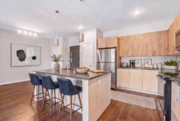Burnsville apartment for rent - A modern kitchen with a bar area and a refrigerator.