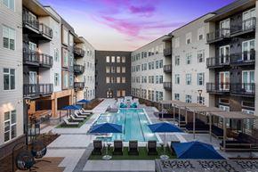 Littleton apartment for rent - A swimming pool surrounded by lounge chairs and umbrellas in a residential area.