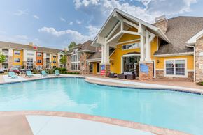 Plymouth apartment for rent - A large swimming pool in front of a yellow building.