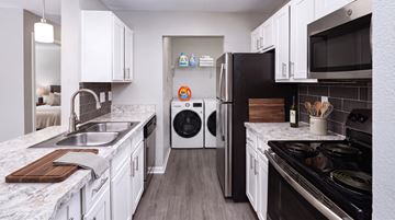 Murfreesboro apartment for rent - A modern kitchen with white cabinets and a black stove top.