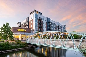Indianapolis apartment for rent - A bridge over a river with a building in the background.